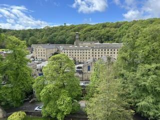 Brookes Mill seen from the top of the church tower, with wooded hillside behind